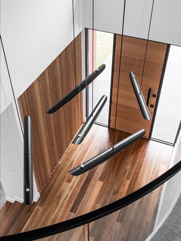 Looking down a timber staircase with black steel handrails